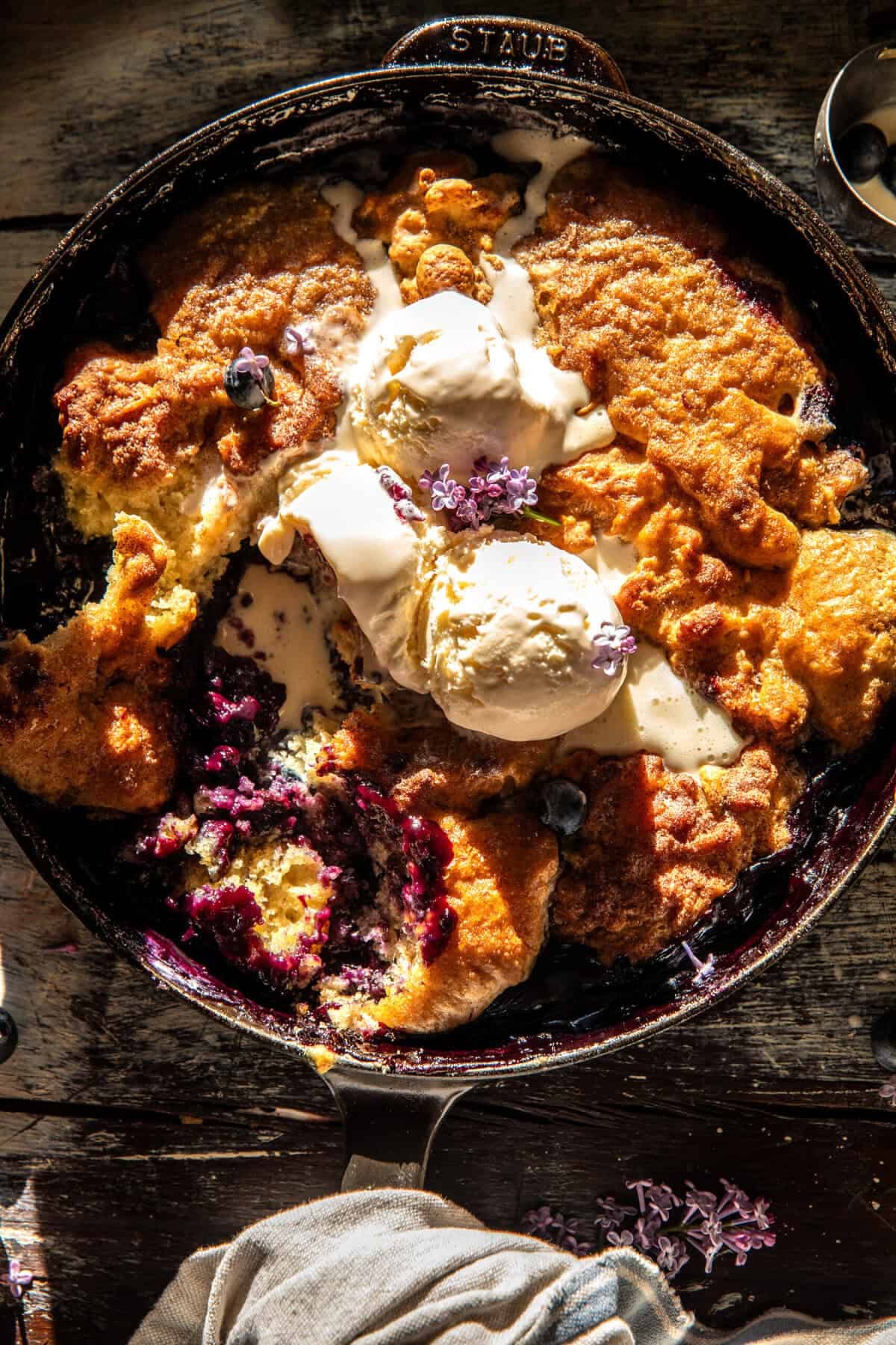 A warm serving of cobbler topped with vanilla ice cream