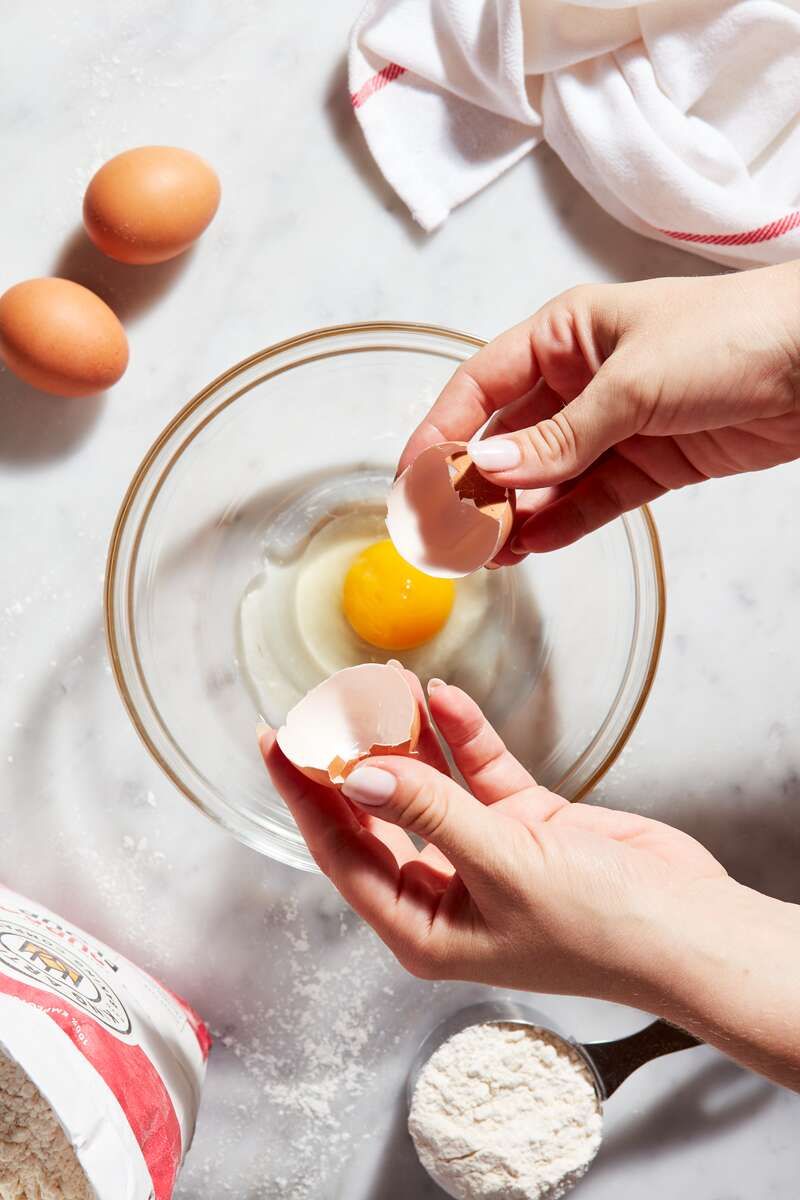 an egg cracked in a mixing bowl.
